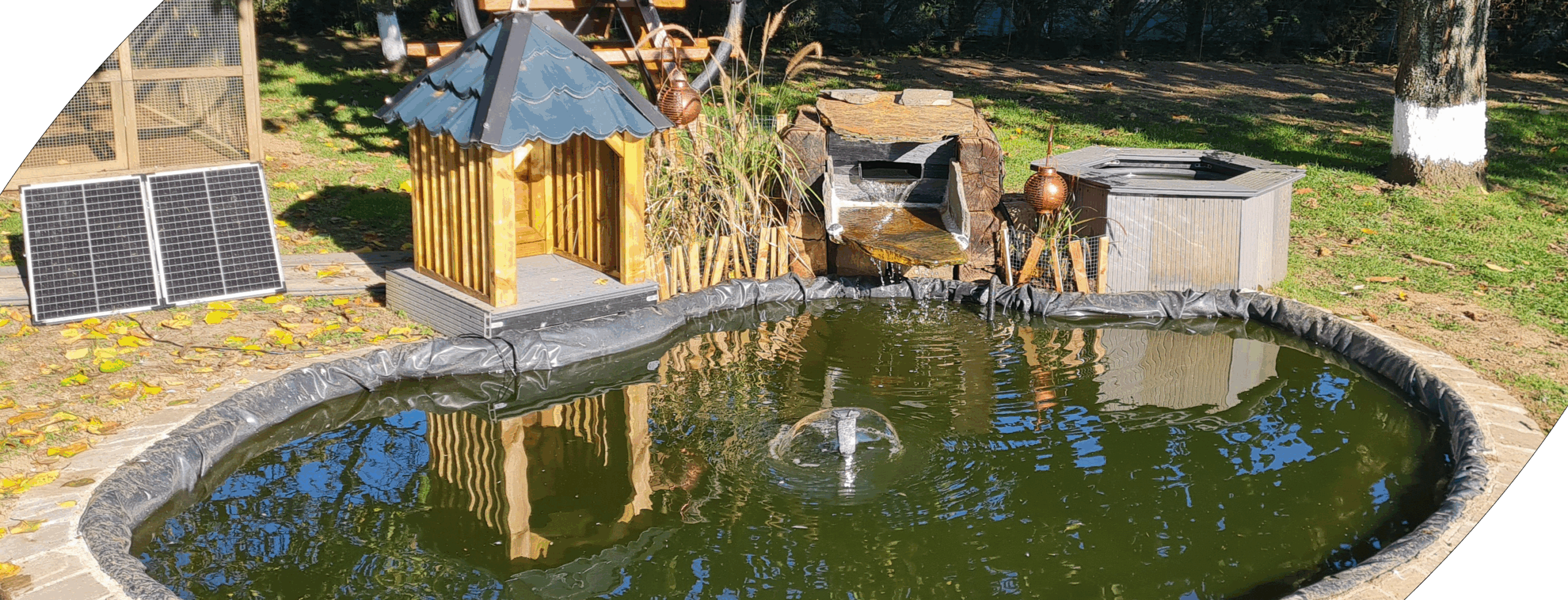 Bassin naturel avec cascade, décoration vintage et pompe à l'énergie solaire
